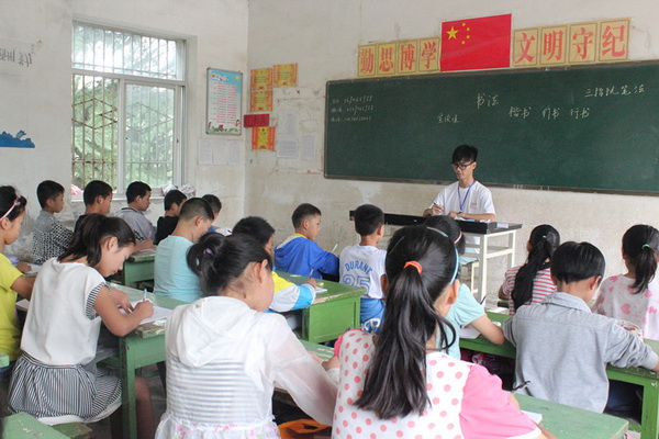 03 图三:支教队员宣俊佳在教授六年级的书法课。孩子们正在认真地学习写书法的正确坐姿。.jpg